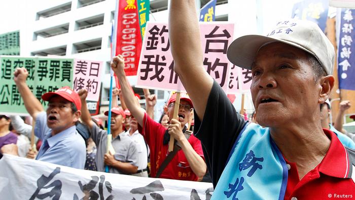 Activists shout slogans during a protest in front of the Japan Interchange Association, the de facto Japanese embassy, in Taipei, August 15, 2012. The activists claim sovereignty of a group of disputed East China Sea islets -- called Senkaku in Japan, Diaoyutai in China and Tiaoyutai in Taiwan -- after attempt of a group of six Taiwanese to set off to Taioyutai failed on Tuesday.  The placards read, "Japan apologizes and compensates our lost in World War II." "Tiaoyutai belong to us." REUTERS/Pichi Chuang (TAIWAN - Tags: POLITICS CIVIL UNREST)