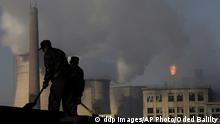 Two workers stand in front of smokestacks at a coal power plant.<br /><br /><br /><br />
------------------------------------------------------------<br /><br /><br /><br />
Arbeiter schaufeln am 30. Nov. 2007 Kohle vor einem Kohlekraftwerk im Bezirk Xiahuayuan, noerdliche chinesische Hebei Provinz. Klimawandel schreitet schneller voran als befuerchtet. Der Leiter des Potsdam-Instituts fuer Klimafolgenforschung, Hans Joachim Schellnhuber, sagte am Donnerstag, 9. Okt. 2008, in diesem Jahrhundert wuerde der Meeresspiegel voraussichtlich sogar um einen Meter ansteigen: "Die Situation ist dramatischer als vor drei Jahren." (ddp images/AP Photo/Oded Balilty, File) --- **FILE** In this Nov. 30, 2007 file photo, backdropped by cooling towers of a power plant and chemical factory, miners shovel coal at a mine in Xiahuayuan county, north China's Hebei province. (ddp images/AP Photo/Oded Balilty)<br /><br /><br /><br />
