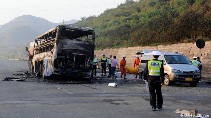 Police and rescuers remove the bodies from a burnt out double-decker sleeper bus after a collision with a tanker near Yanan in northern China's Shaanxi province on August 26, 2012.  At least 36 people died in the fiery collision between a methanol tanker and a double-decker sleeper bus in China's worst traffic accident in more than a year.      CHINA OUT      AFP PHOTO        (Photo credit should read STR/AFP/GettyImages)