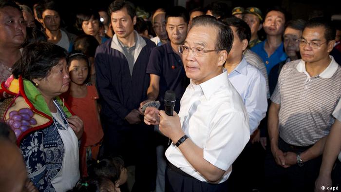 In this photo released by China's Xinhua News Agency, Chinese Premier Wen Jiabao, center, talks to earthquake victims in Yiliang County of Zhaotong, southwest China's Yunnan Province, early Saturday, Sept. 8, 2012. At least 80 people were killed and more than 100,000 residents were evacuated after Friday's quakes toppled thousands of houses and sent boulders cascading across roads in a remote mountainous area along the borders of Guizhou and Yunnan provinces. (AP Photo/Xinhua, Huang Jingwen) NO SALES