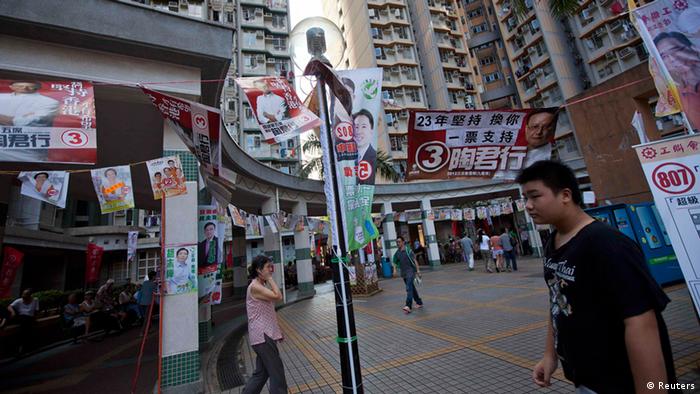 People walk past campaign banners of various candidates for the Legislative Council election campaign in Hong Kong September 9, 2012. Hong Kong residents voted for a new legislature on Sunday, a day after the territory's Beijing-backed leader backed down on a plan to introduce a compulsory Chinese school curriculum after tens of thousands of people took to the streets. REUTERS/Tyrone Siu (CHINA - Tags: POLITICS ELECTIONS)