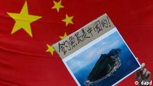 A protester demonstrating against Japan's claim to disputed islands holds a picture of the rocky islands, known as Senkaku to Japanese and Diaoyu to Chinese, reading 