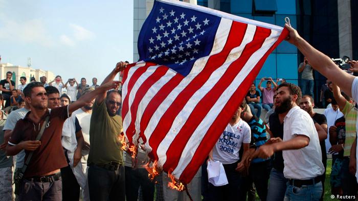 Tunisian protesters burn the U.S. flag during a demonstration outside the U.S. embassy in Tunis September 12, 2012. Tunisian police fired teargas and rubber bullets into the air on Wednesday to disperse a protest over a U.S.-made film depicting the Prophet Mohammad near the U.S. Embassy in the capital Tunis, a Reuters reporter said. REUTERS/Zoubeir Souissi (TUNISIA - Tags: POLITICS CIVIL UNREST RELIGION)
