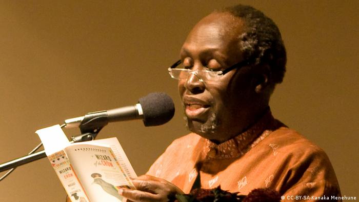 Kenyan author Ngugi wa Thiong'o reading a book using a microphone.