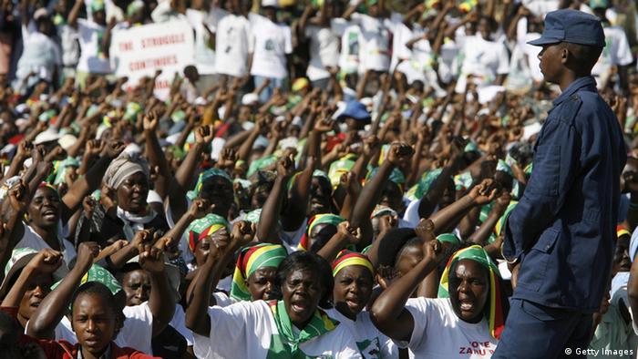 Supporters of Zimbabwe's President Robert Mugabe cheer during his final rally in Harare on June 26, 2008.