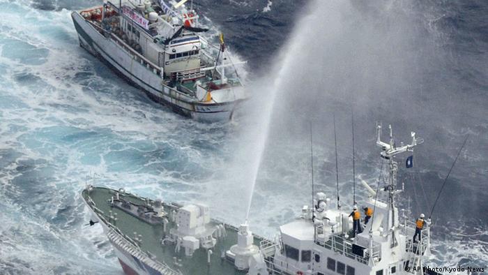 A Japan Coast Guard patrol boat sprays water against a Taiwanese fishing boat, top, near disputed islands, called Senkaku in Japan and Diaoyu in China, in the East China Sea, Tuesday, Sept. 25, 2012. Japanese coast guard ships fired water cannon to push back Taiwanese vessels Tuesday in the latest confrontation over a group of the tiny islands, as the main contenders, China and Japan, opened talks in a diplomatic effort to tamp down tensions. (AP Photo/Kyodo News) JAPAN OUT, MANDATORY CREDIT, NO LICENSING IN CHINA, FRANCE, HONG KONG, JAPAN AND SOUTH KOREA