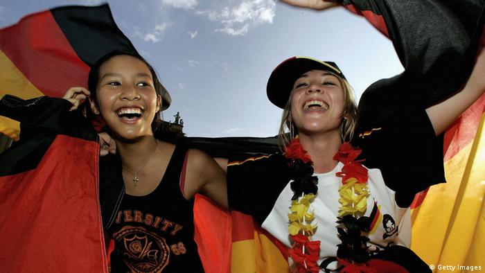 STUTTGART, GERMANY - JULY 08: German football supporters cheer at a public viewing area prior to their teams match on July 8, 2006 in Stuttgart, Germany. Germany faces Portugal in their FIFA World Cup 2006 third-round play-off football match in Stuttgart. (Photo by Ralph Orlowski/Getty Images) 