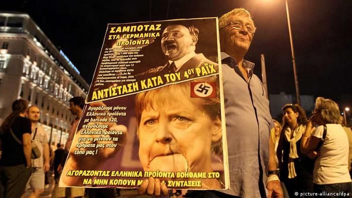 A demonstrator holds a poster depicting Adolf Hitler and German Chancellor Angela Merkel during a protest in front of the Parliament building against new austerity measures in Athens (c) dpa - Bildfunk
