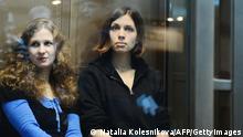 Alyokhina and Tolokonnikova sitting in a glass-walled cage in a court in Moscow (Photo: Natalia Kolesnikova)