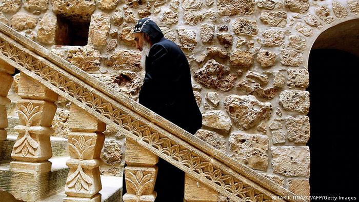 A priest climbs the stairs at the Mor Gabriel monastery in Turkey. (Photo credit should read TARIK TINAZAY/AFP/Getty Images) 