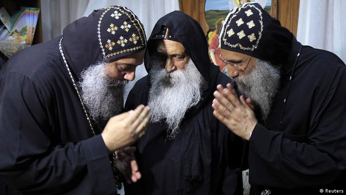 Candidates for leading the Coptic Church Father Bakhomius of Virgin Mary in Wadi Natroun (L), Father Seraphim of Virgin Mary (R) and Father Rafael from St Marina Monastery (C) talk during the mass held at the Klod Bek Coptic Church in Cairo October 22, 2012. The mass was held to introduce the five bishops nominated to succeed the late Pope Shenouda III who died on March 17, 2012 at the age of 88. REUTERS/Mohamed Abd El Ghany (EGYPT - Tags: RELIGION)