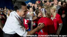 Mitt Romney akiweka sahihi yake katika fulana ya mfuasi wake mjini Des Moines, Iowa Novemba 4