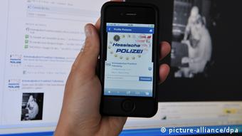 A hand holding a smartphone with the logo of the police of the German state of Hesse
Photo: Arne Dedert dpa/lhe 