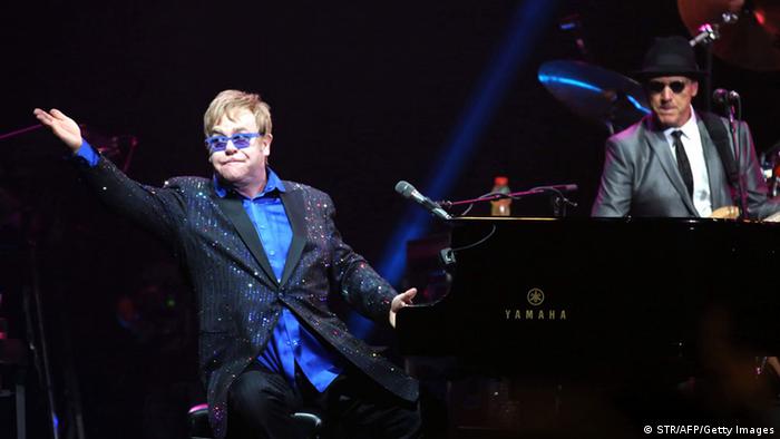 This picture taken on November 25, 2012 shows pop-rock balladeer Elton John (L) performing at his concert in Wukesong Stadium in Beijing. Elton dedicated his Beijing show to Chinese dissident Ai Weiwei -- a controversial move the artist said on November 26 was unlikely to make the nation's cultural minders happy. CHINA OUT AFP PHOTO (Photo credit should read STR/AFP/Getty Images) 