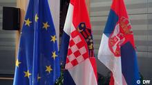 Two red, white and blue flags hang next to the blue and yellow flag of the EU
(Photo: Marina Maksimovic/DW)