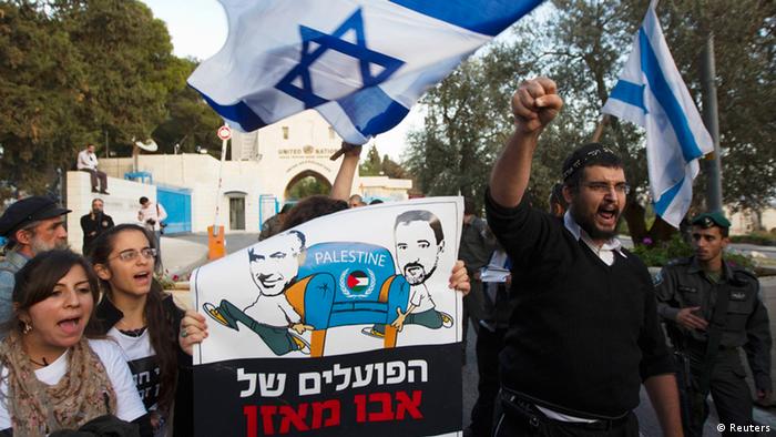 Israeli ultranationalist right-wing protesters hold a placard depicting Prime Minister Benjamin Netanyahu (L) and Foreign Minister Avigdor Lieberman during a demonstration against the Palestinian Authority's efforts to secure a diplomatic upgrade at the United Nations, outside the U.N. offices in the West Bank village of Jabel Mukaber, near Jerusalem November 29, 2012. (Photo via Reuters)