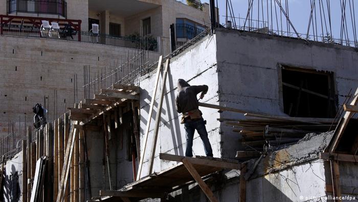 epa03460234 A photograph released on 06 November 2012 shows a Palestinian at a building site in the East Jerusalem neighborhood of Pizgat Ze'ev, 08 January 2012. Israel announced on 06 November, 2012, the US election day, that it intends to build an additional 1,285 new housing units in the West bank settlement of Ariel (72 units) and in Pizgat Ze'ev (607 units) and the East Jerusalem neighborhood of Ramot (606 units). Many consider both Pizgat Ze'ev and Ramot to be Jewish settlements as they are built on what was Arab land before the 1967 war. EPA/JIM HOLLANDER
