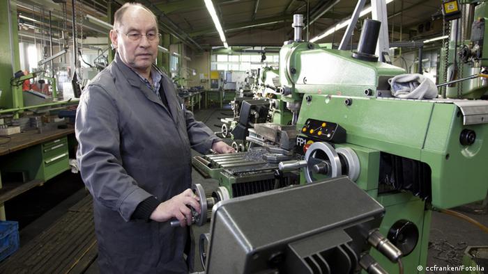An older man works at a machine