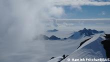 The Antartic is difficult terrain for scientists to access. Here, clouds cross ice-covered polar mountains. 