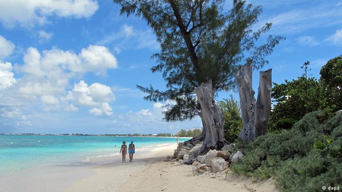 In this Aug. 3, 2012, photo, tourists walk along Seven Mile Beach in Grand Cayman Island. (Photo: David McFadden/ AP/dapd)
