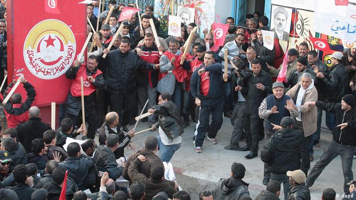 Members of the leftist UGTT union, background, react during clashes with League members 
Foto:Amine Landoulsi/AP/dapd
