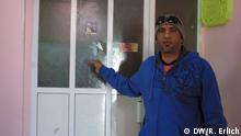 Abdullah al Mizo points to a broken window in his apartment (photo: Reese Erlich)