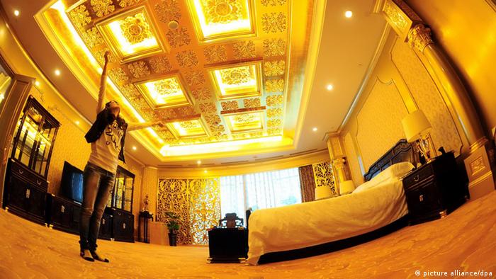 A traveler enjoys in a presidential suite in Longxi International Hotel in Jiangyin, east Chinas Jiangsu province, 6 October 2011. Huaxi village in east Chinas Jiangsu Province grabbed attention after completing a 328-meter high building that houses a statue of an ox made from a ton of gold. The village which has been dubbed as Chinas richest village spent more than 3 billion yuan (about 0.46 billion U.S. dollars) to build the 74-story building. The building opened as a hotel, named Longxi International Hotel, on October 8th to celebrate the 50th anniversary of the villages founding. Photo Yang Kejia