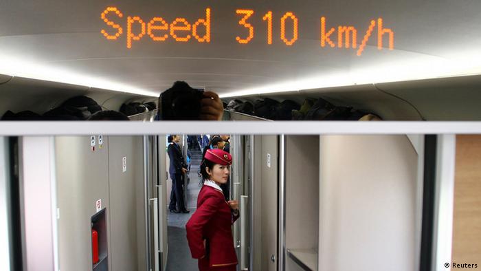 An attendant stands inside a high-speed train during an organized experience trip from Beijing to Zhengzhou, as part of a new rail line, December 22, 2012. China will open the world's longest high-speed rail line next week when a link between Beijing and the southern metropolis of Guangzhou is inaugurated, officials said on Saturday. REUTERS/China Daily (CHINA - Tags: BUSINESS TRANSPORT) CHINA OUT. NO COMMERCIAL OR EDITORIAL SALES IN CHINA