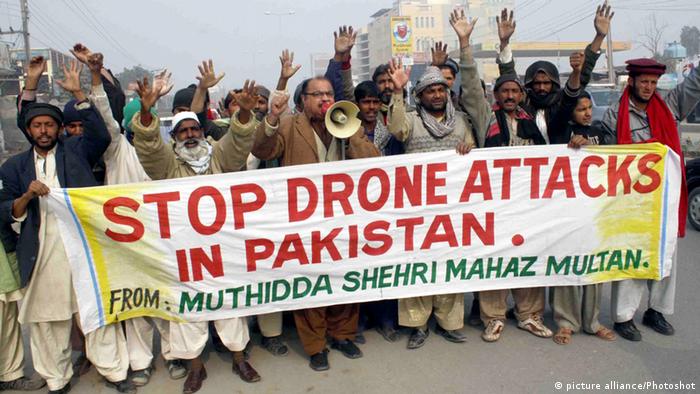 A large group of Pakistani protestors carries a sign that reads, Stop drone attacks in Pakistan.
