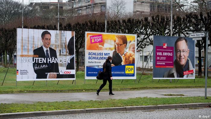 Woman walking past election billboards 
Foto: Nigel Treblin/dapd