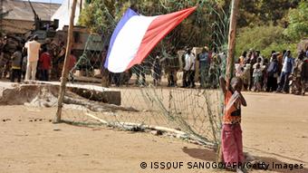A boy stands next to a French national flag hung on a goalpost as French soldiers arrive in the Malian town of Diabaly, on January 21, 2013. 
Photo: ISSOUF SANOGO/AFP/Getty Images