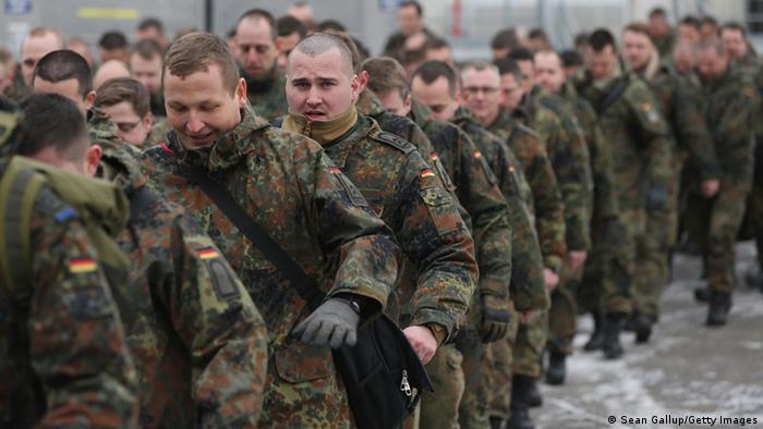 Men in green battle dress uniforms march in file
Photo: Sean Gallup/Getty Images) 

