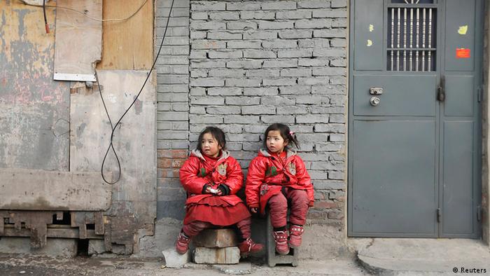 Two 4-year-old twin sisters rest against a wall at a poor residential area for migrant workers on the outskirts of Beijing January 12, 2013. Chinese rural children are expected to get better care from the government including more nutritious meals, safe school buses and better accommodation facilities. Currently, China has about 58 million rural children living away from their parents, or 28.29 percent of the total number of rural children, Xinhua reported. REUTERS/Jason Lee (CHINA - Tags: POLITICS SOCIETY IMMIGRATION POVERTY)