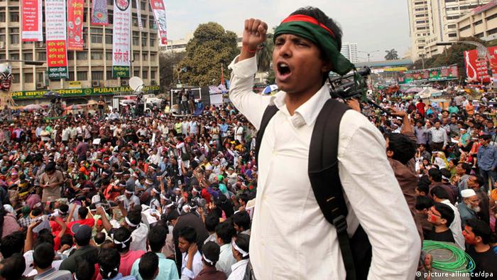 epa03581692 Bangladeshi activists hold national flag and shout slogans at the Shahbagh intersection, in Dhaka, Bangladesh, 13 February 2013. Reports state that protesters gathered for the ninth day against the life sentence given to the leader of the 'Jamaat-e-Islami' party, Quader Molla, a sentence the protesters call too lenient and demanding capital punishment instead. EPA/MONIRUL ALAM +++(c) dpa - Bildfunk+++