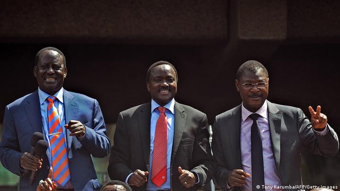 Kenyan Prime Minister Raila Odinga (L), Vice President Kalonzo Musyoka (C) and Trade Minister Moses Wetangula gesture at supporters in Nairobi on December 4, 2012 after agreeing to form a powerful alliance as running mates in presidential elections due in March 2013. The former rivals along with leaders of 10 other smaller parties, signed an agreement in front of thousands of supporters to form the Coalition for Reform and Democracy (CORD) party. Odinga is widely tipped to be the presidential candidate with Musyoka as his deputy, although no formal announcement was made. AFP PHOTO / TONY KARUMBA (Photo credit should read TONY KARUMBA/AFP/Getty Images) 
