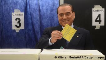 Italian former Prime Minister Silvio Berlusconi casts his ballot at a polling station on February 24, 2013 in Milan. Italians fed up with austerity went to the polls on Sunday in elections where the centre-left is the favourite, as Europe held its breath for signs of fresh instability in the eurozone's third economy. AFP PHOTO / OLIVIER MORIN (Photo credit should read OLIVIER MORIN,OLIVIER MORIN/AFP/Getty Images) 
