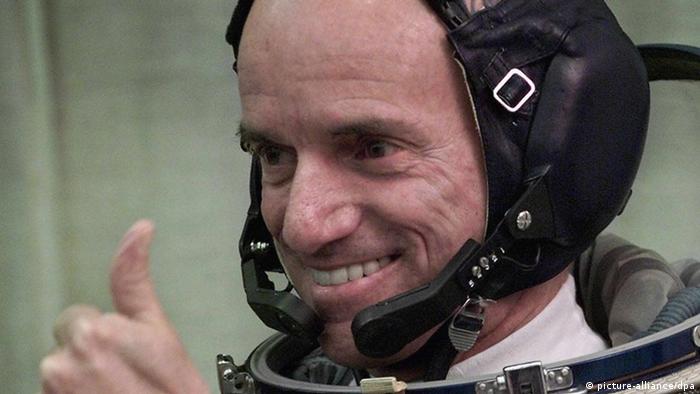 Dennis Tito giving thumbs-up while wearing spacesuit