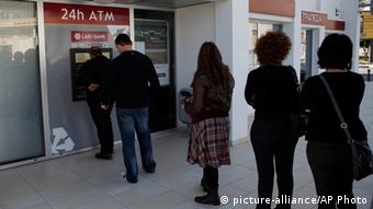 People queue to use an ATM machine in Cyprus (photo: AP Photo/Petros Karadjias)
