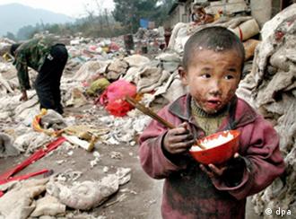 Ein vierjähriger Junge isst Reis aus einer Schale, während sein Vater auf der Müllhalde in Guiyang (Provinz Guizhou) nach Verwertbarem sucht (Archivfoto vom 28.12.2003). Nicht nur in Entwicklungsländern werden Kinder aufgrund der vorhandenen Armut vielfach nicht ausreichend ernährt und medizinisch versorgt. "Der Zusammenhang zwischen sozialer Benachteiligung und negativen Auswirkungen auf die Gesundheit bereits bei Kindern und Jugendlichen ist auch in Deutschland unbestritten", sagt die Direktorin der Bundeszentrale für gesundheitliche Aufklürung (BZgA). Foto: Woo Jun (Zu dpa KORR: "Arme Kinder oft auch kranke Kinder - Nicht nur in der Dritten Welt" vom 01.04.2005) +++(c) dpa - Bildfunk+++