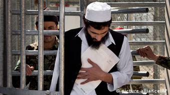 An Afghan prisoner leaves with his release papers from the Parwan Detention Facility after the U.S. military gave control of its last detention facility to Afghan authorities in Bagram, outside Kabul, Afghanistan, Monday, March 25, 2013. (AP Photo/Anja Niedringhaus) 