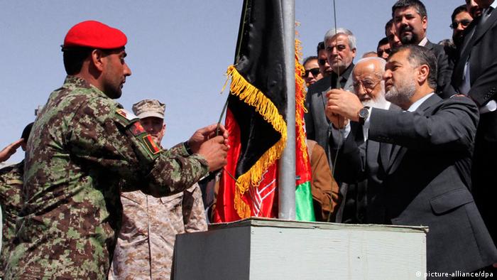 Bismillah Muhammadi (R) Afghan Defense Minister raises national flag during the Bagram Prison handover ceremony, on the outskirts of Kabul, Afghanistan, 25 March 2013. (Photo: EPA/S. SABAWOON +++(c) dpa - Bildfunk+++)