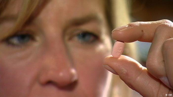 Woman examining a pill