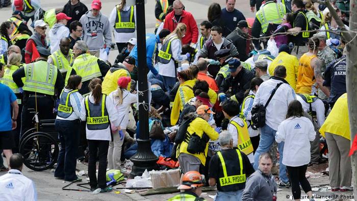 Medical workers aid injured people at the finish line of the 2013 Boston Marathon following an explosion in Boston, Monday, April 15, 2013. Two explosions shattered the euphoria of the Boston Marathon finish line on Monday, sending authorities out on the course to carry off the injured while the stragglers were rerouted away from the smoking site of the blasts. (AP Photo/Charles Krupa)
