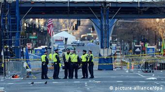 Police officers stand near the finish line of the Boston Marathon as an investigation continues into dual bombings at the site, in Boston, USA, 16 April 2013. Three people were killed and over 100 were injured when two bombs exploded on 15 April 2013 at the finish line of the marathon. EPA/JUSTIN LANE 