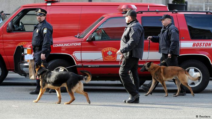 Police officers and their bomb detecting dogs investigate after explosions near the finish line of the Boston Marathon in Boston, Massachusetts April 15, 2013. U.S. investigators led by the FBI are poring over video and photographs from the widely watched Boston Marathon for clues to determine who is responsible for two bombs that exploded near the finish line on Monday, killing three people and injuring more than 100, officials said. REUTERS/Neal Hamberg (UNITED STATES - Tags: SPORT ATHLETICS CRIME LAW)