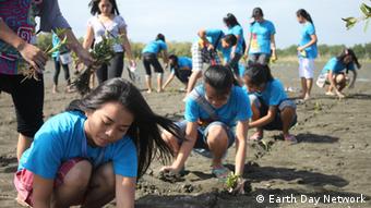 Children in blue Earth Day t-shirts are planting trees. (Photo: Earth Day Network, delivered by Sarah Steffen)
