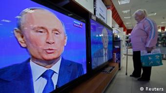 A woman watches televisions broadcasting a nationwide phone-in with Russian President Vladimir Putin in an electronics shop
REUTERS/Alexander Demianchuk