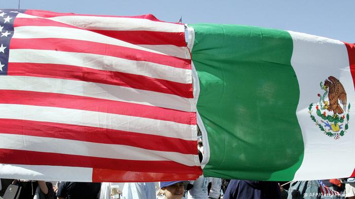 Protesters hold an American and Mexican flag that has been stitched together 
Photo credit DON EMMERT/AFP/Getty Images)
