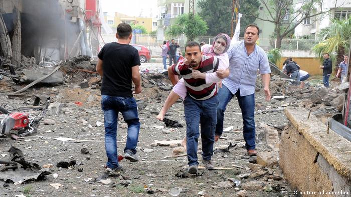 epa03695954 People help victims after an explosion in Reyhanli District, Hatay, Turkey, 11 May 2013. At least 13 people were killed and 22 wounded following explosions on 11 May in southern Turkey near the Syrian border, Turkish television NTV reported. Initial reports said two car bombs exploded in Reyhanli, a town in the province of Hatay, which borders Syria. EPA/CEM GENCO/ANADOLU AGENCY TURKEY OUT EDITORIAL USE ONLY/NO SALES/NO ARCHIVES