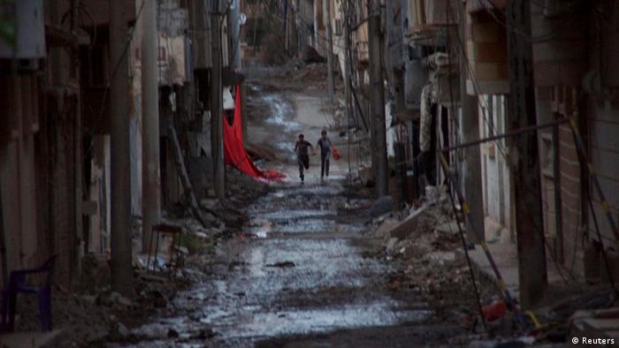 People run down a street in Deir al-Zor (Photo: REUTERS/Khalil Ashawi)